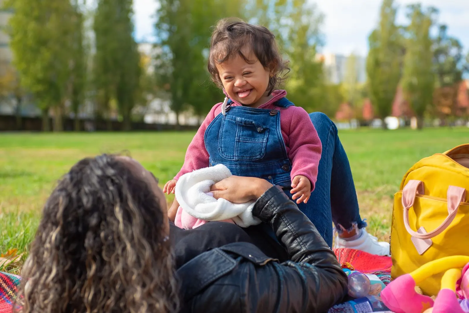 A mother and her child with Down syndrome enjoying a picnic in the park
